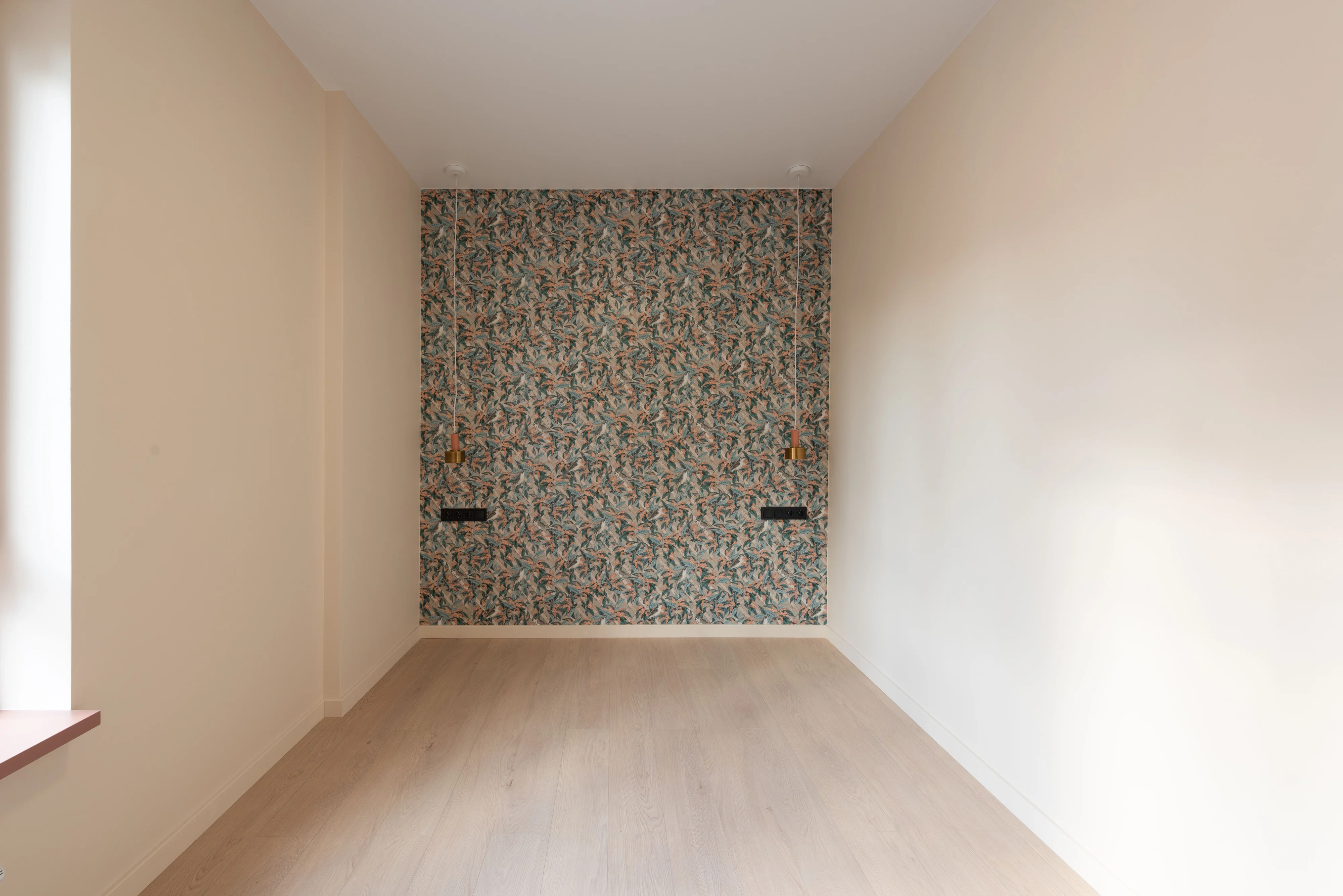 Soft botanical wallpaper across the far wall of a quiet, light-filled room