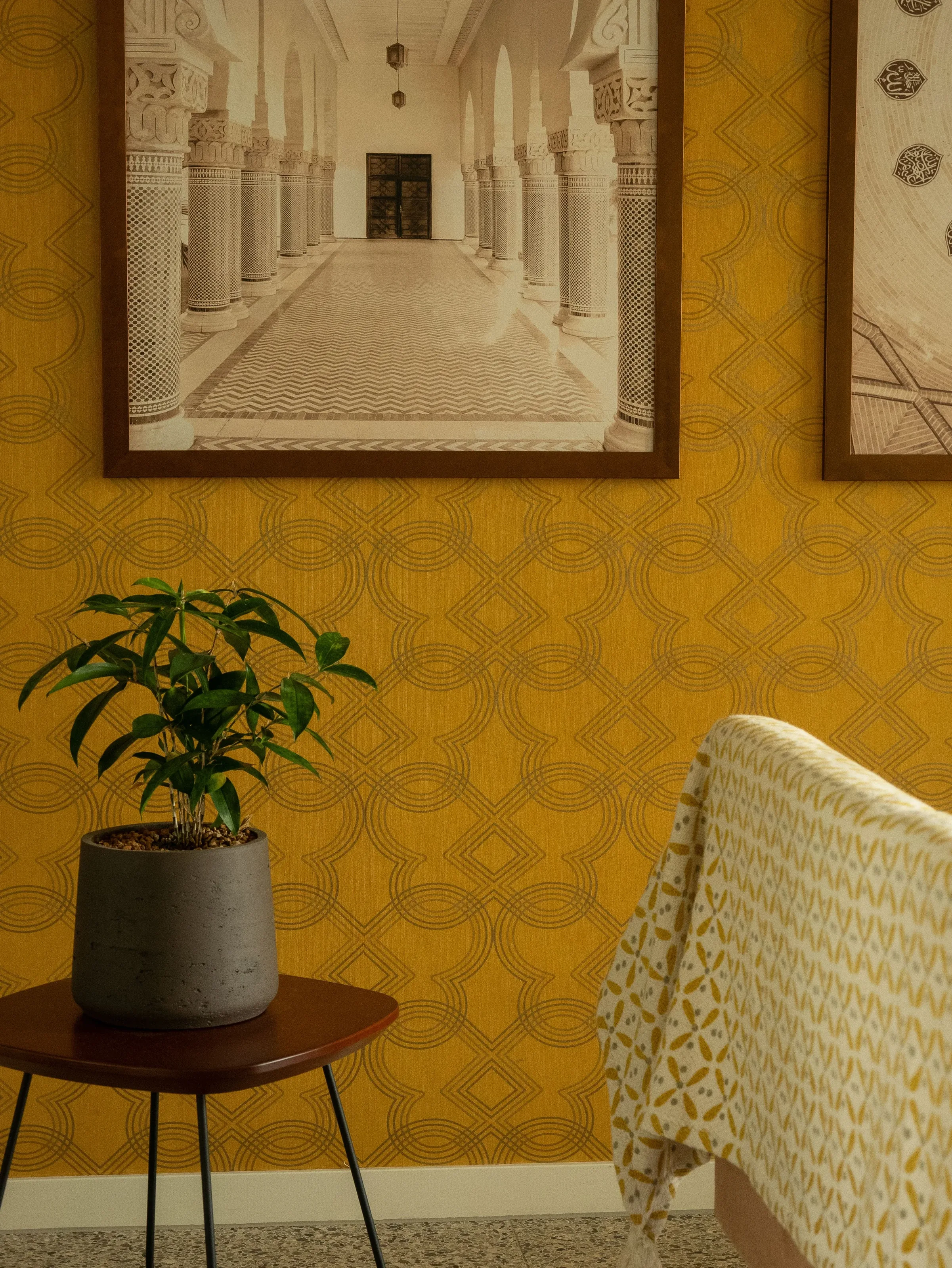 Rich golden geometric wallpaper paired with natural textures and warm furnishings