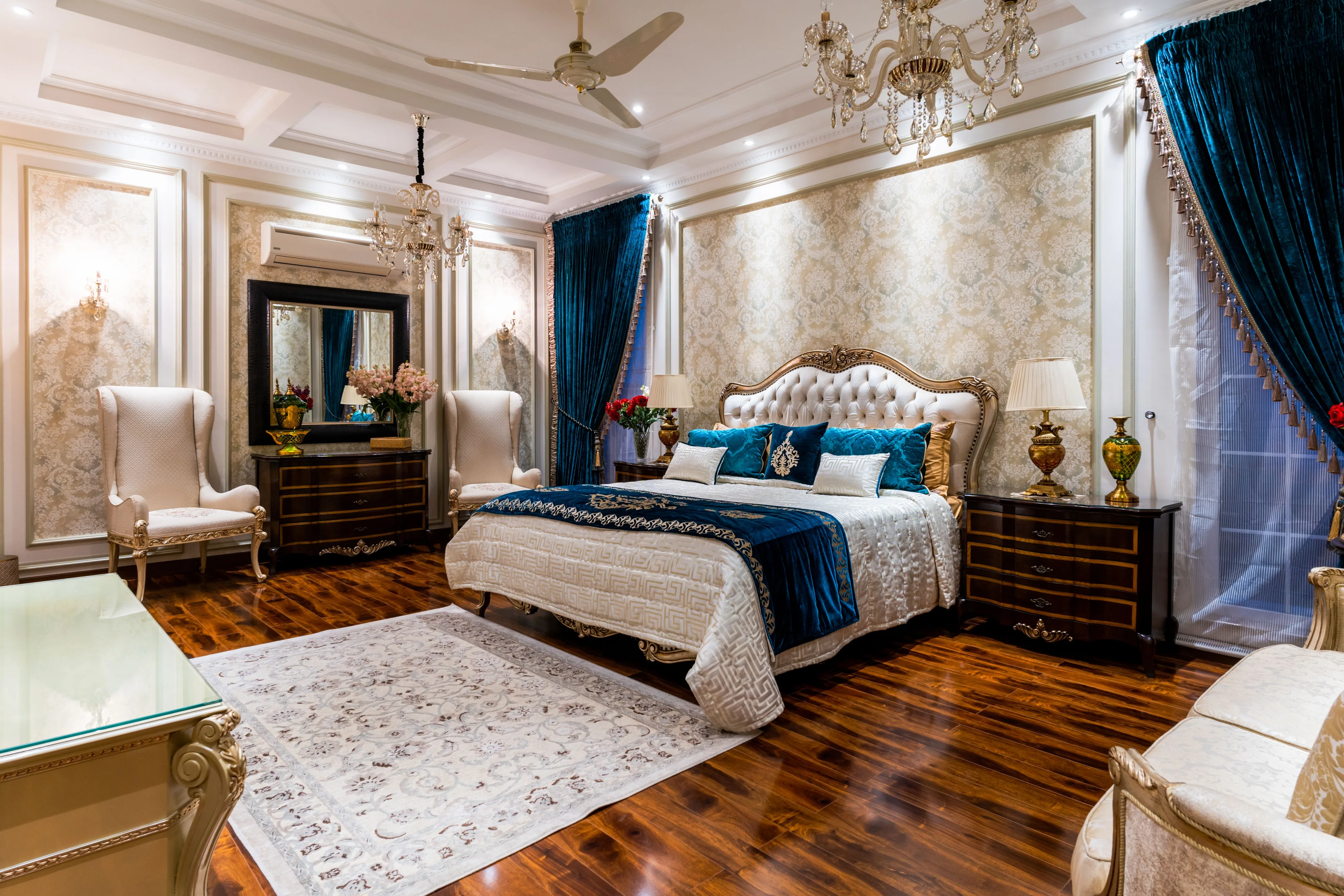 Ornate pale patterned wallpaper in a tailored bedroom with deep blue accents